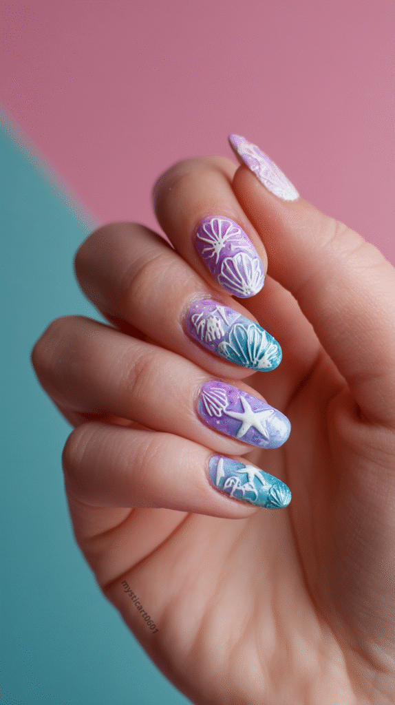 Hand with long gradient mermaid nails in lavender, pink, and aqua, decorated with white starfish and shell patterns.